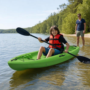 Child in a life jacket paddling the green youth kayak